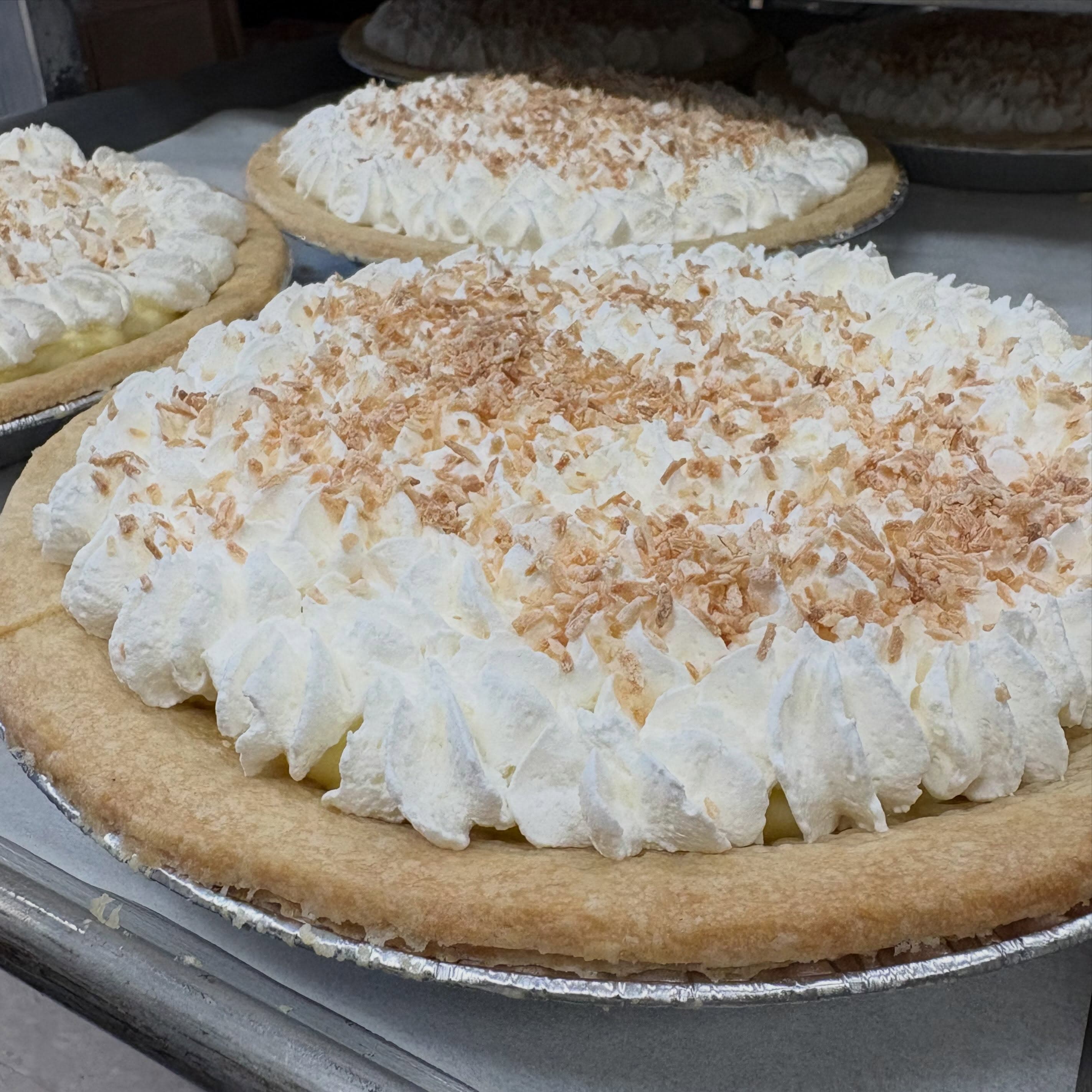 Coconut cream pies topped with piped whipped cream and toasted coconut, fresh from the farm bakery