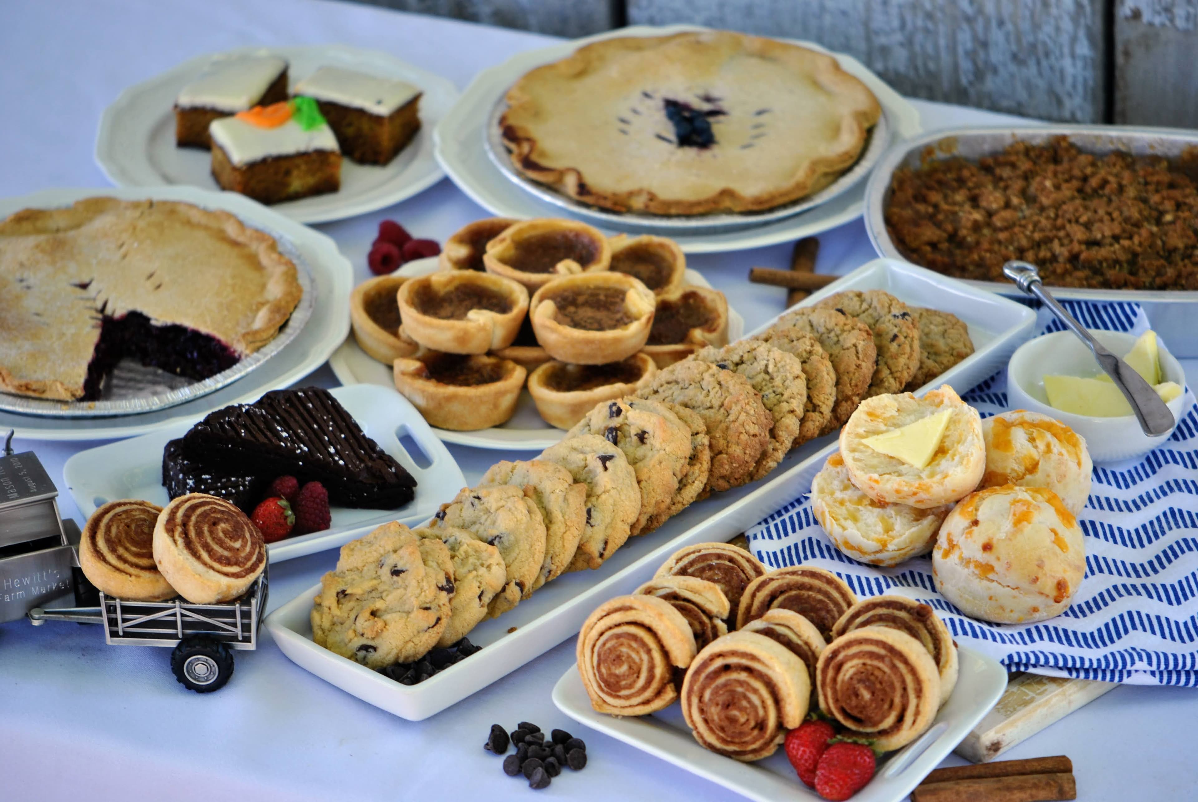 A table of the bakery's pies, butter tarts, cookies, cinnamon rolls, cheese biscuits and carrot cake, beside a toy Hewitt's Farm Market truck